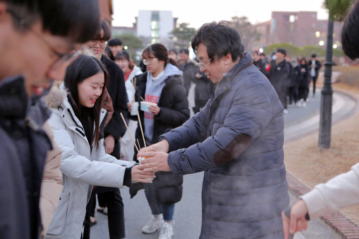 (사진2) 장순흥 한동대 총장이 학생들에게 어묵 꼬치와 떡볶이를 나눠주며 격려하고 있다.